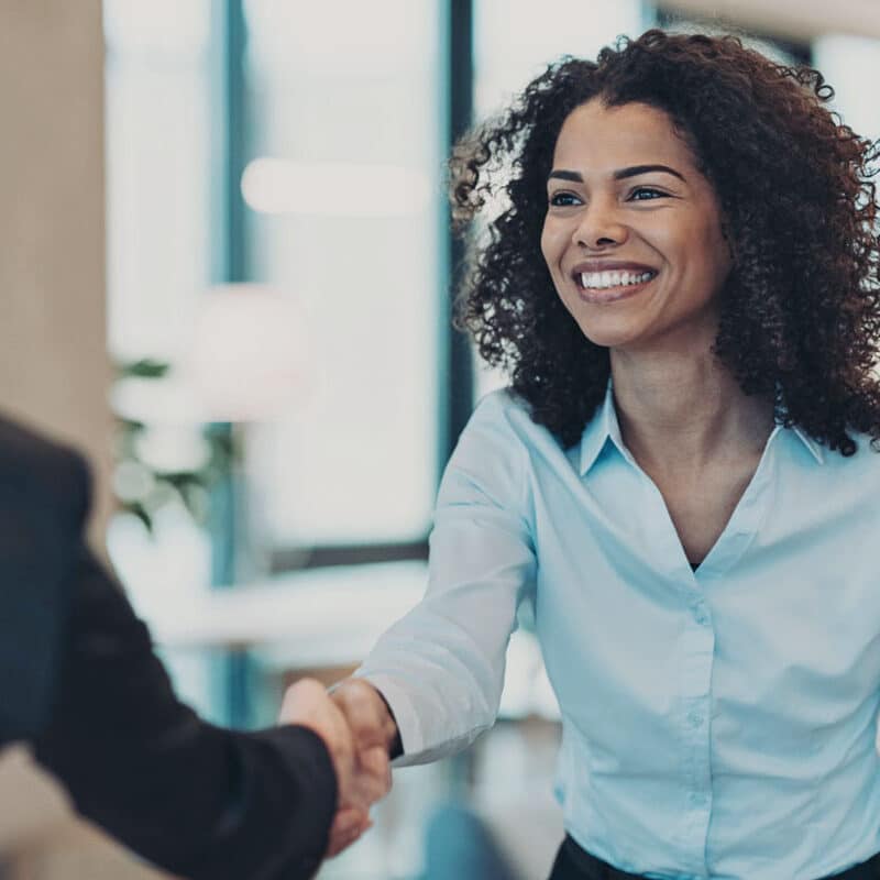 Two people shaking hands in a business meeting
